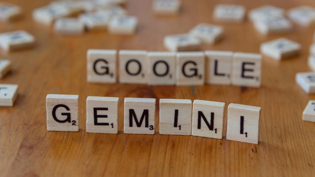 Scrabble tiles spelling out Google and Gemini on a wooden table, focusing on AI concepts.