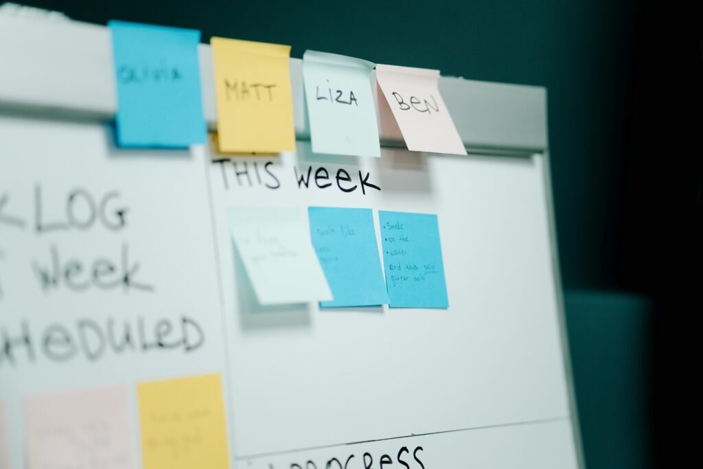 Close-up of a whiteboard with colorful sticky notes for task organization and planning.